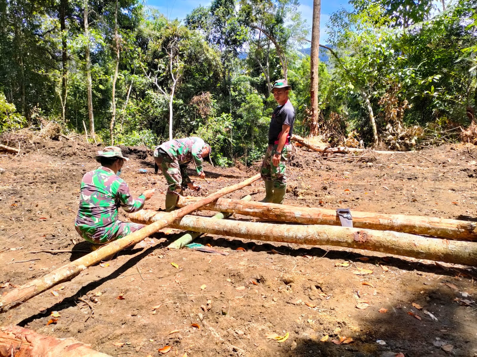 Personel dan Warga Mengunakan Pikulan Kayu di Lokasi TMMD 112 Untuk Gorong - gorong
