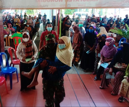 Babinsa Tidak Segan Bopong Lansia dalam Membantu Kelancaran Vaksinasi