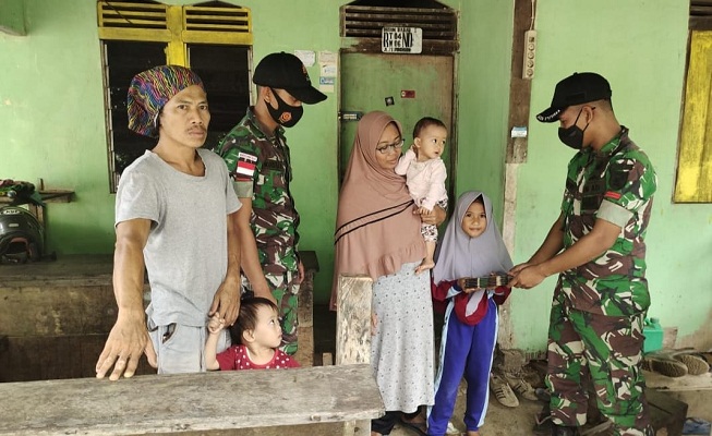 Anggota Satgas Yonif 144/JY Berikan Bantuan Buku Tulis kepada Anak